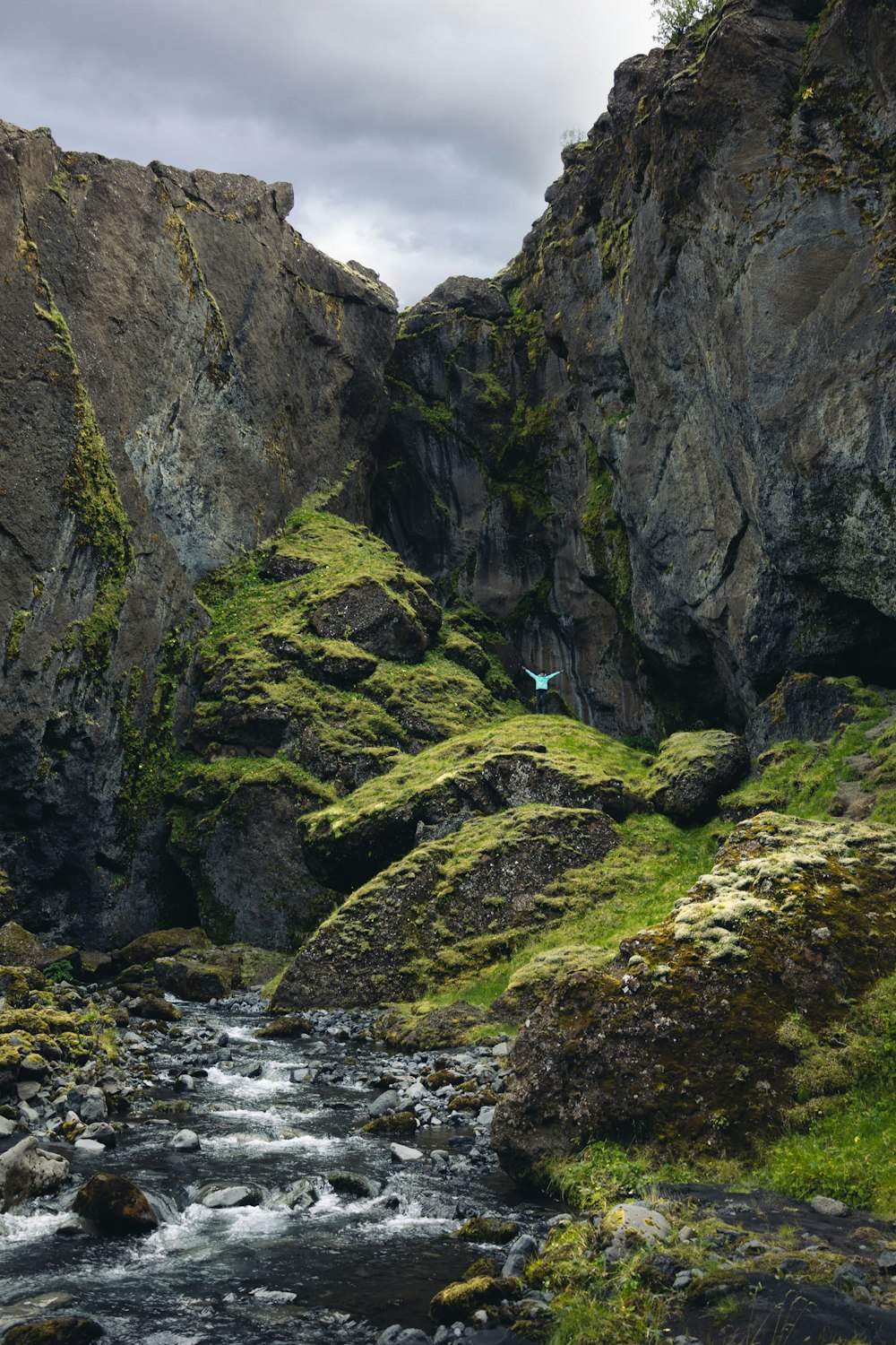 a rocky river with a person walking on it