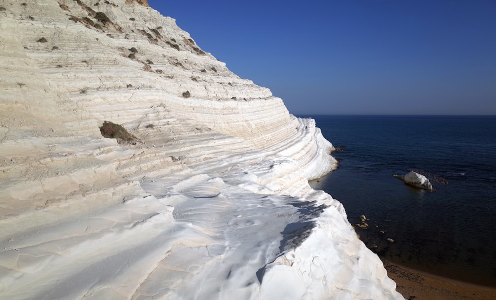 una spiaggia rocciosa con onde che si infrangono su di essa