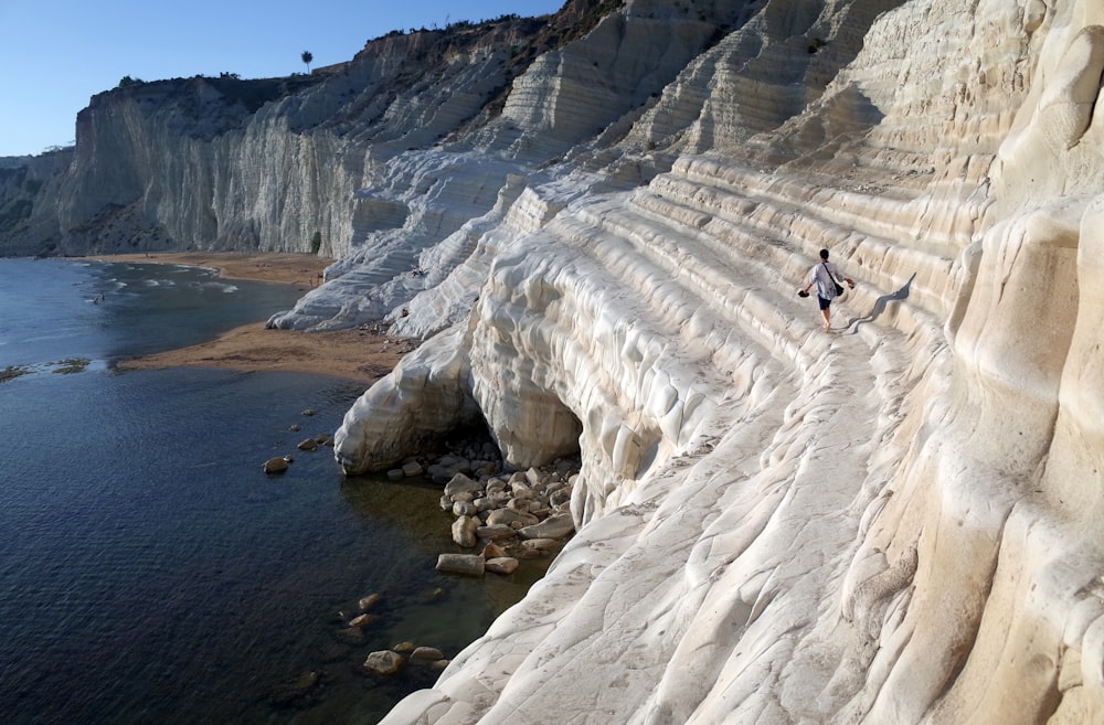 a person walking on a rocky beach