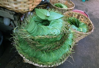 Fresh gorran toula leaves arranged on a woven African basket.