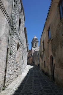 a cobblestone street between two stone buildings