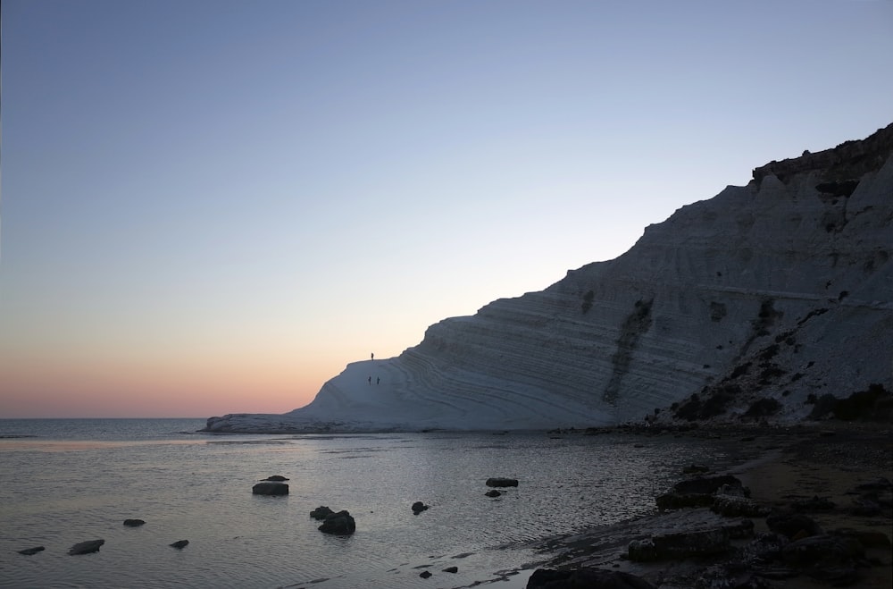 una montaña nevada con un cuerpo de agua debajo