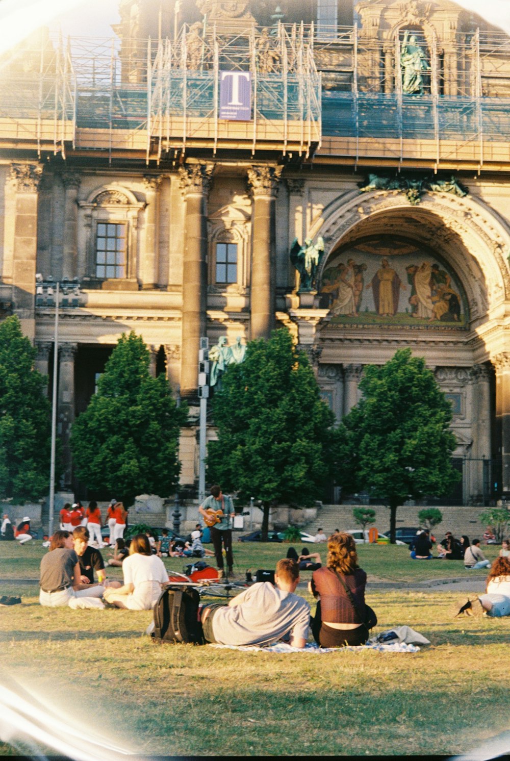 a group of people sitting on the ground in front of a building