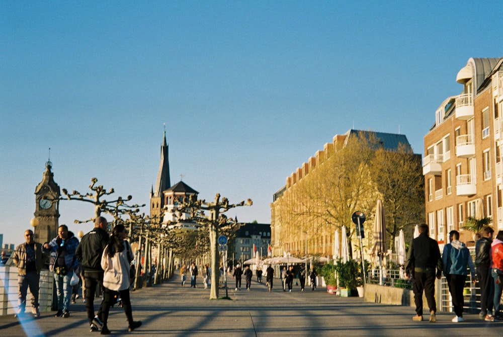 a group of people walking on a street with buildings on either side