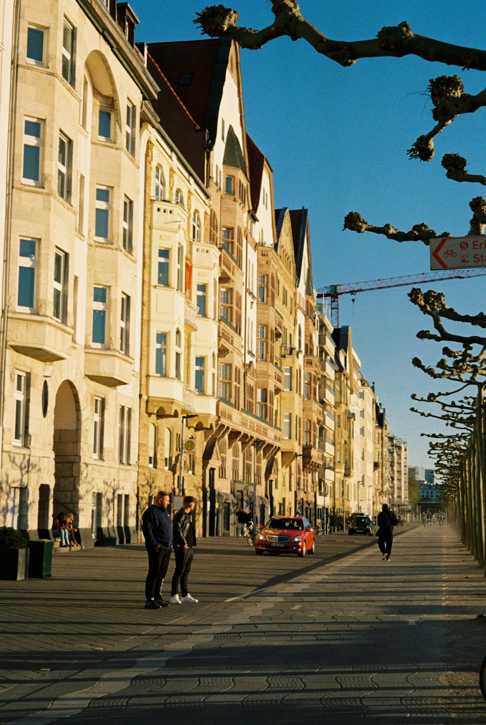 a group of people walking on a street between buildings