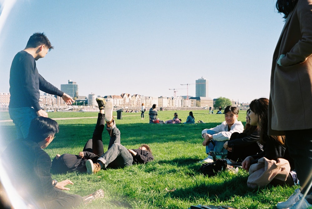 a group of people sitting on the grass