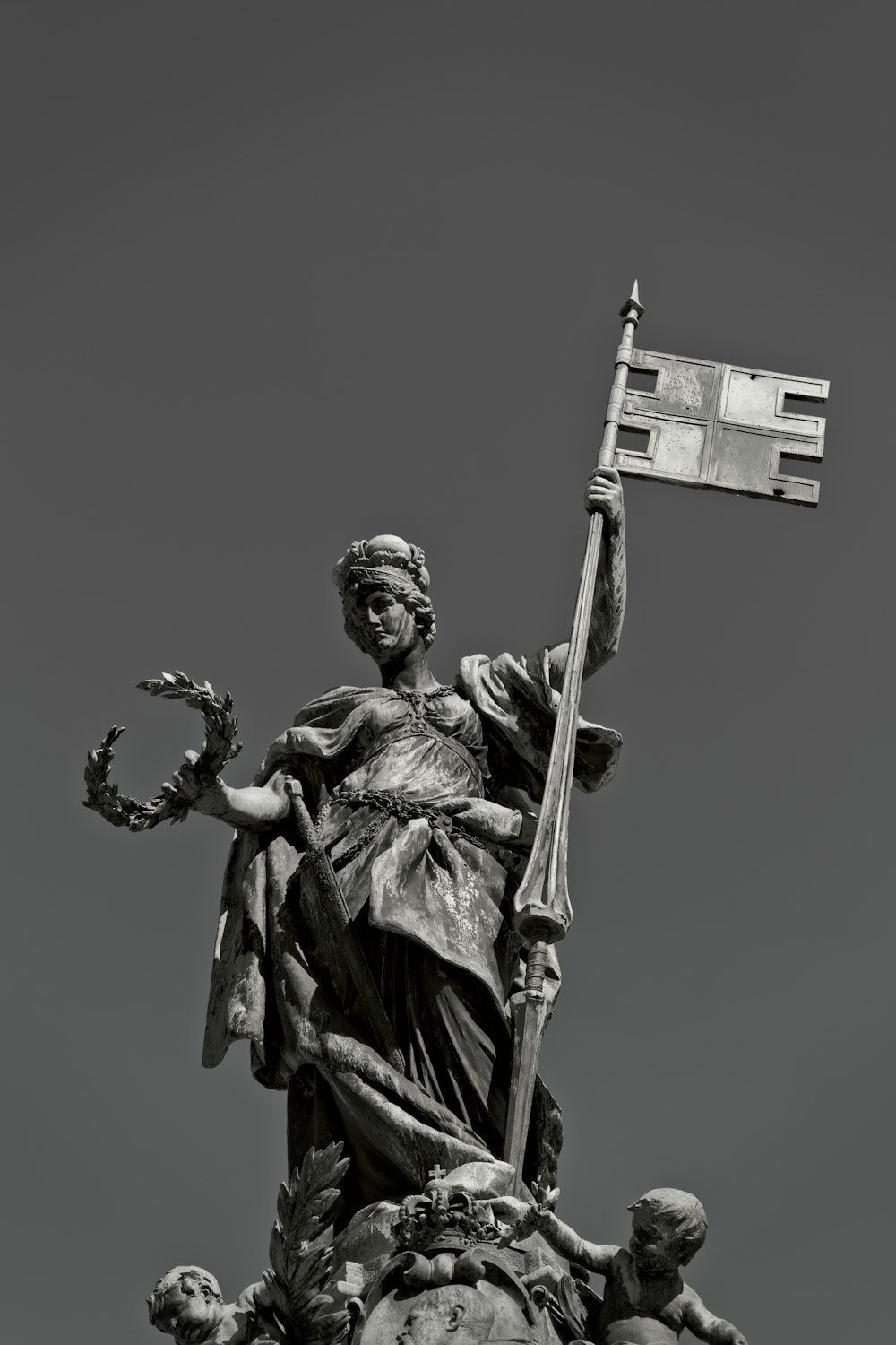 une statue d’une personne tenant une croix