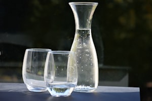 Une carafe en verre et deux verres d’eau pétillante