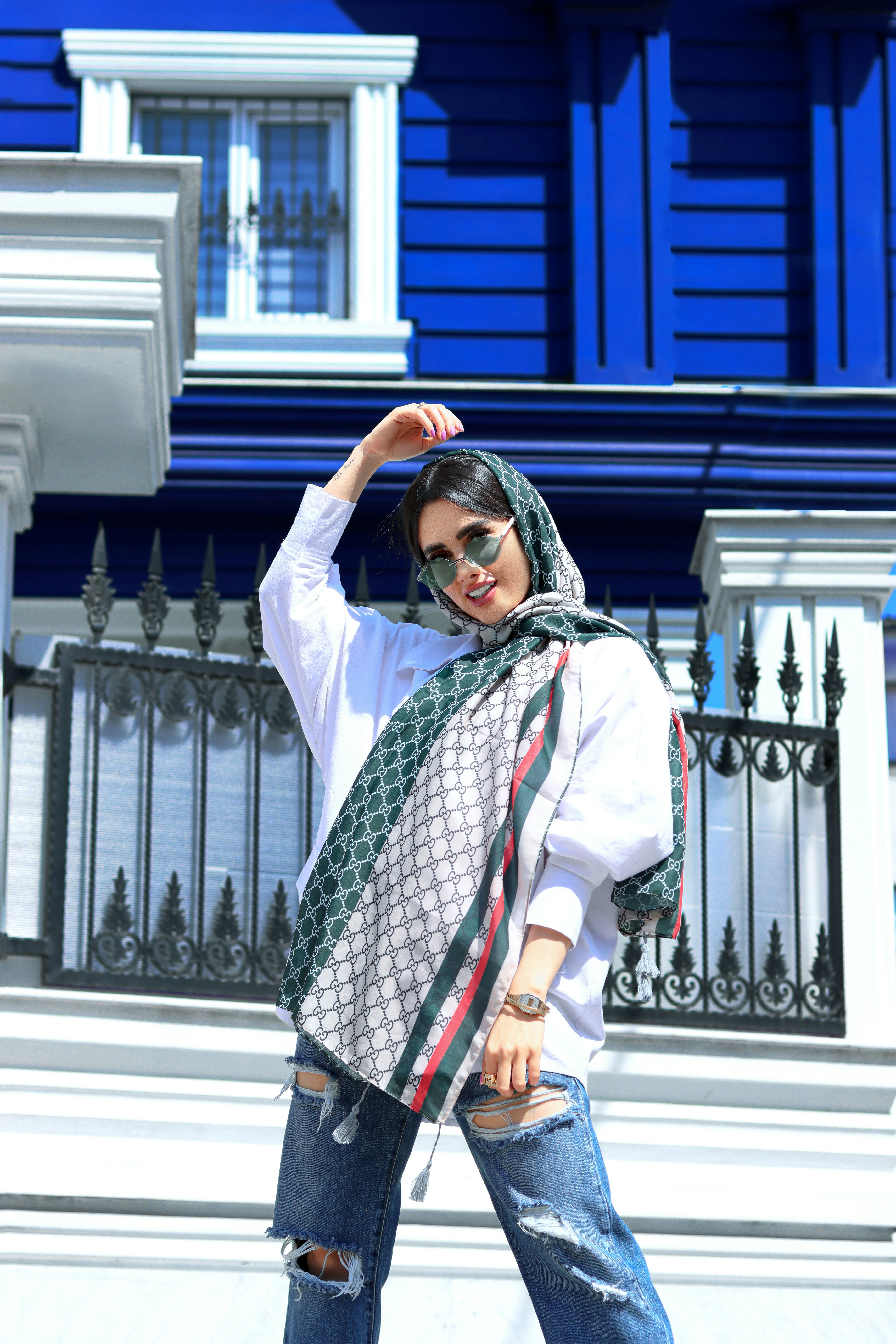A woman with a scarf on her head and a building in the background photo ...