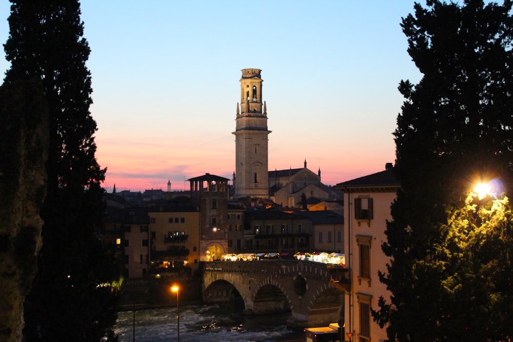 a bridge with a tower and buildings on the side