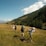 A group of hikers smiling on a mountain trail during a sunny day.