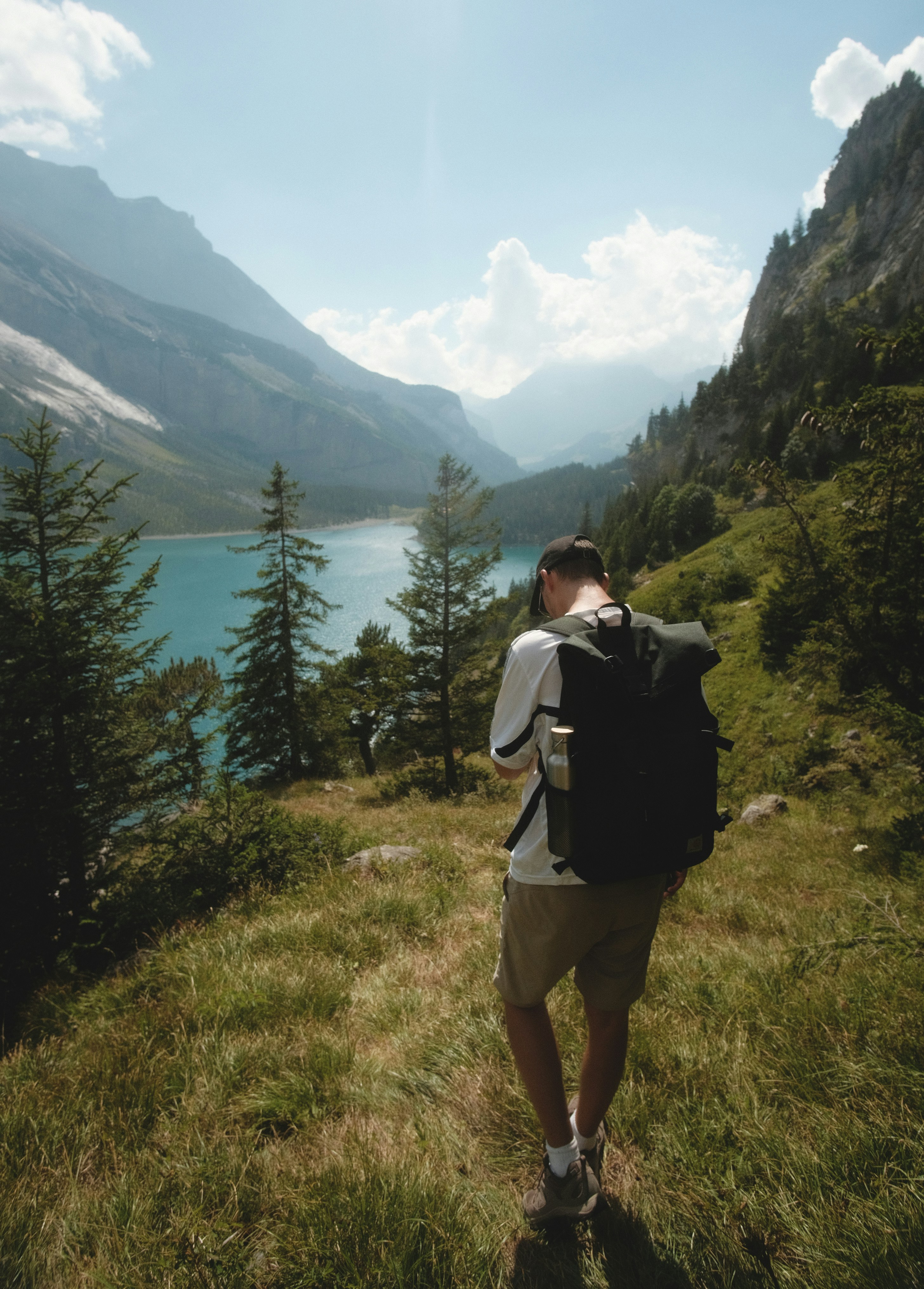 a man walking on a trail in a mountainous region