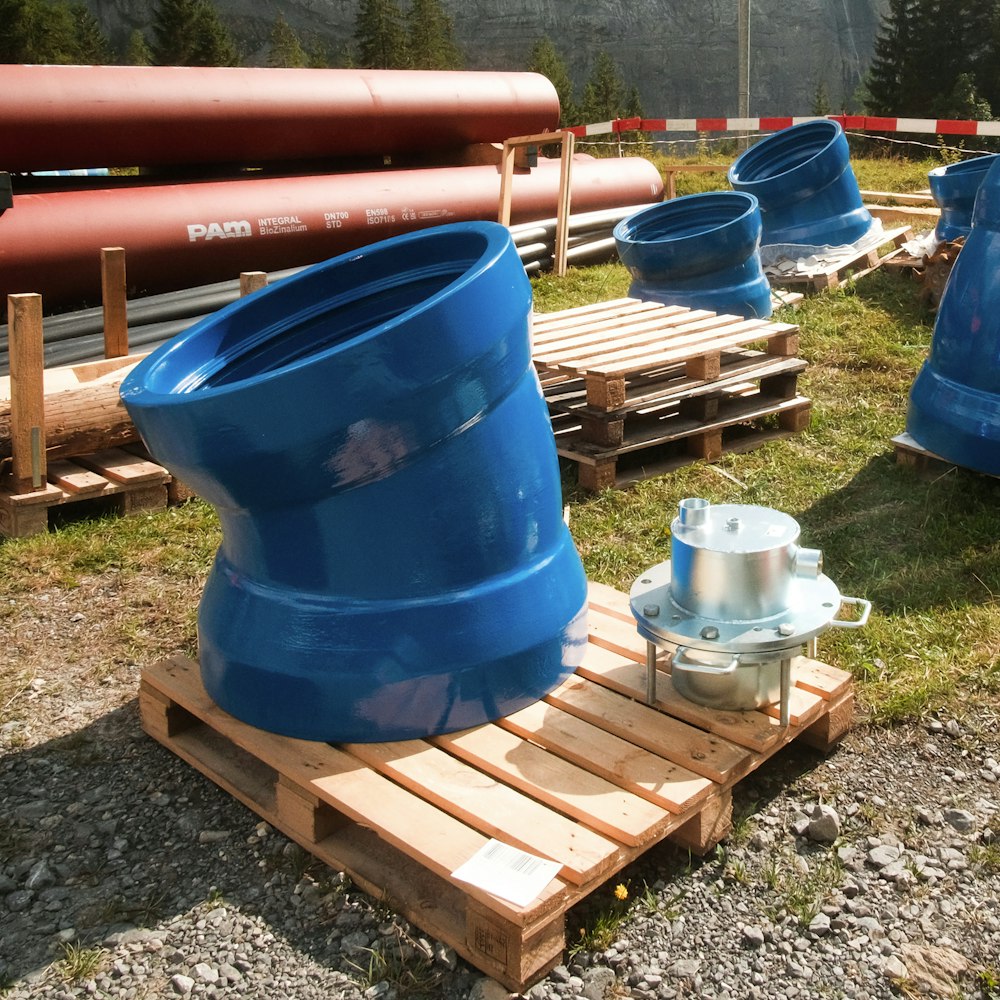 a group of blue and orange water tanks on a wooden bench