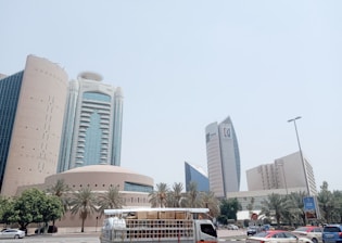 A moving truck driving through a Dubai city street with modern buildings in the background.