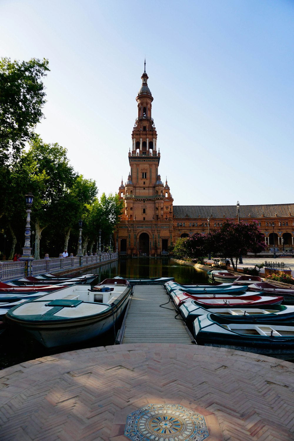a building with a tower and boats in front of it