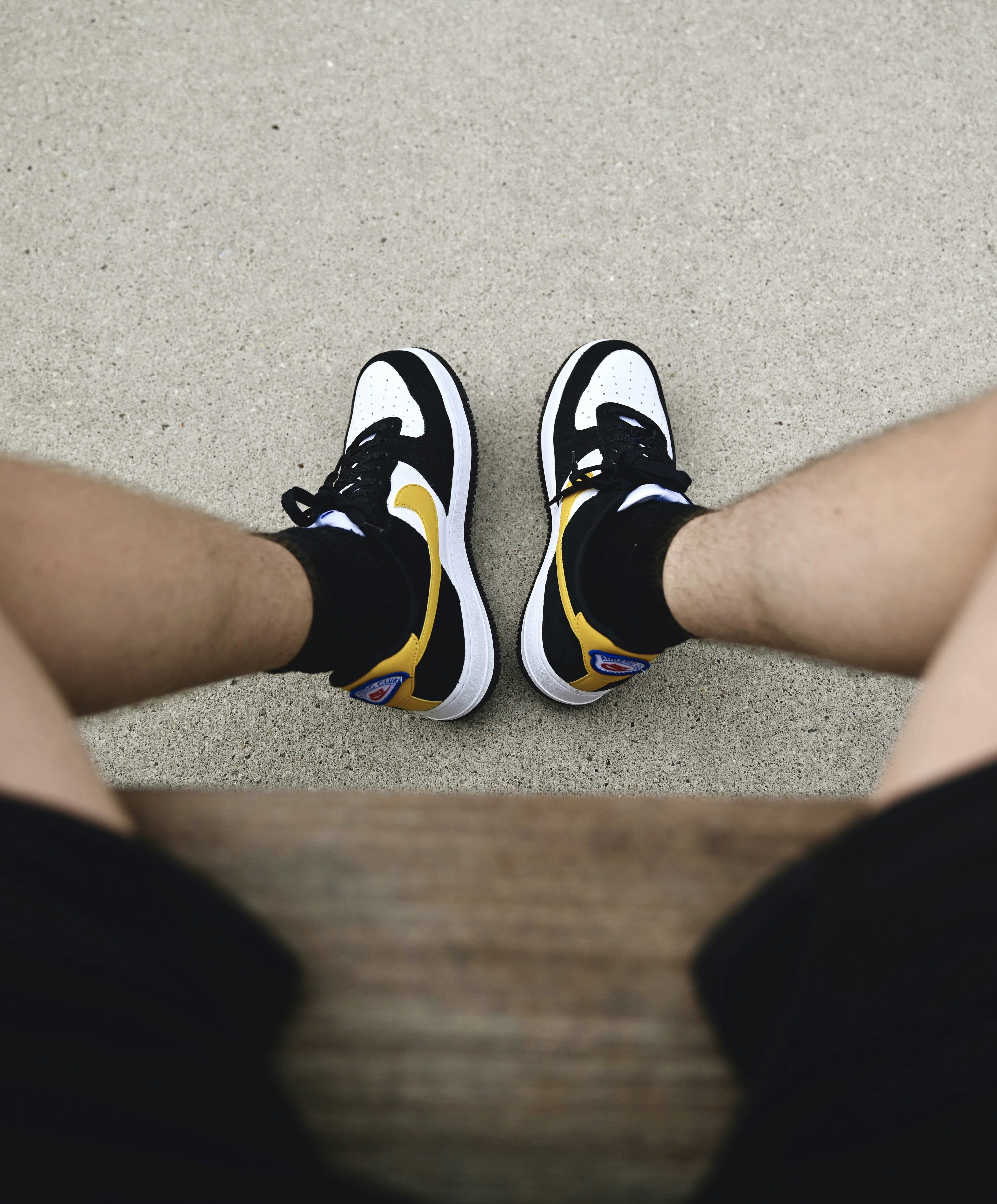 a pair of feet with black and yellow shoes