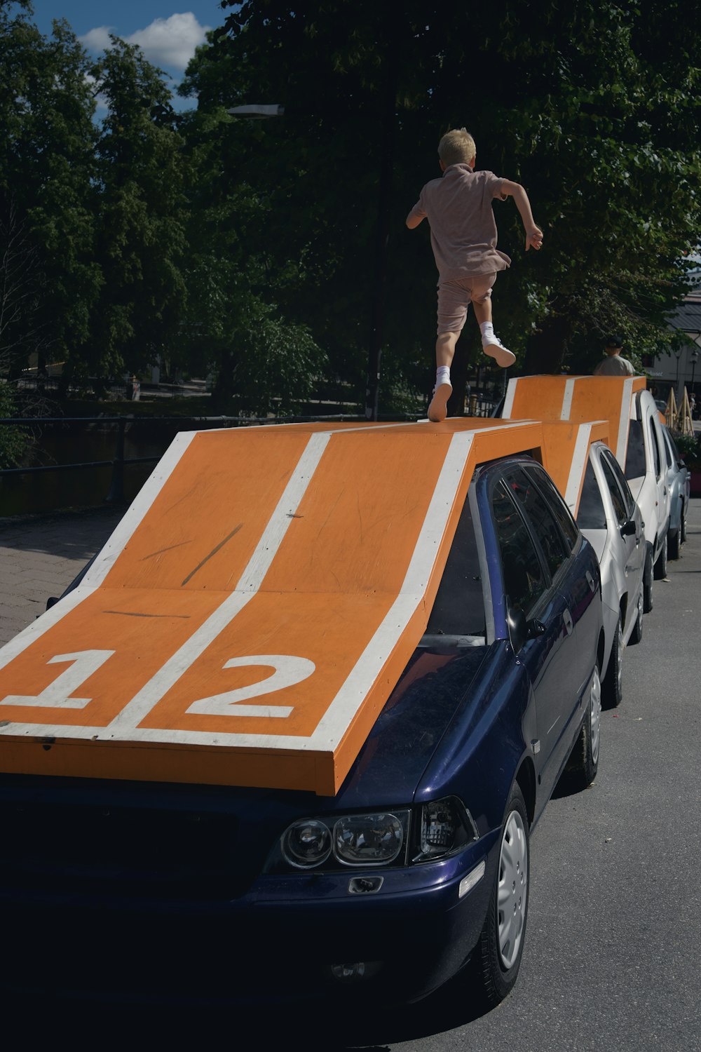 a boy jumping off a car