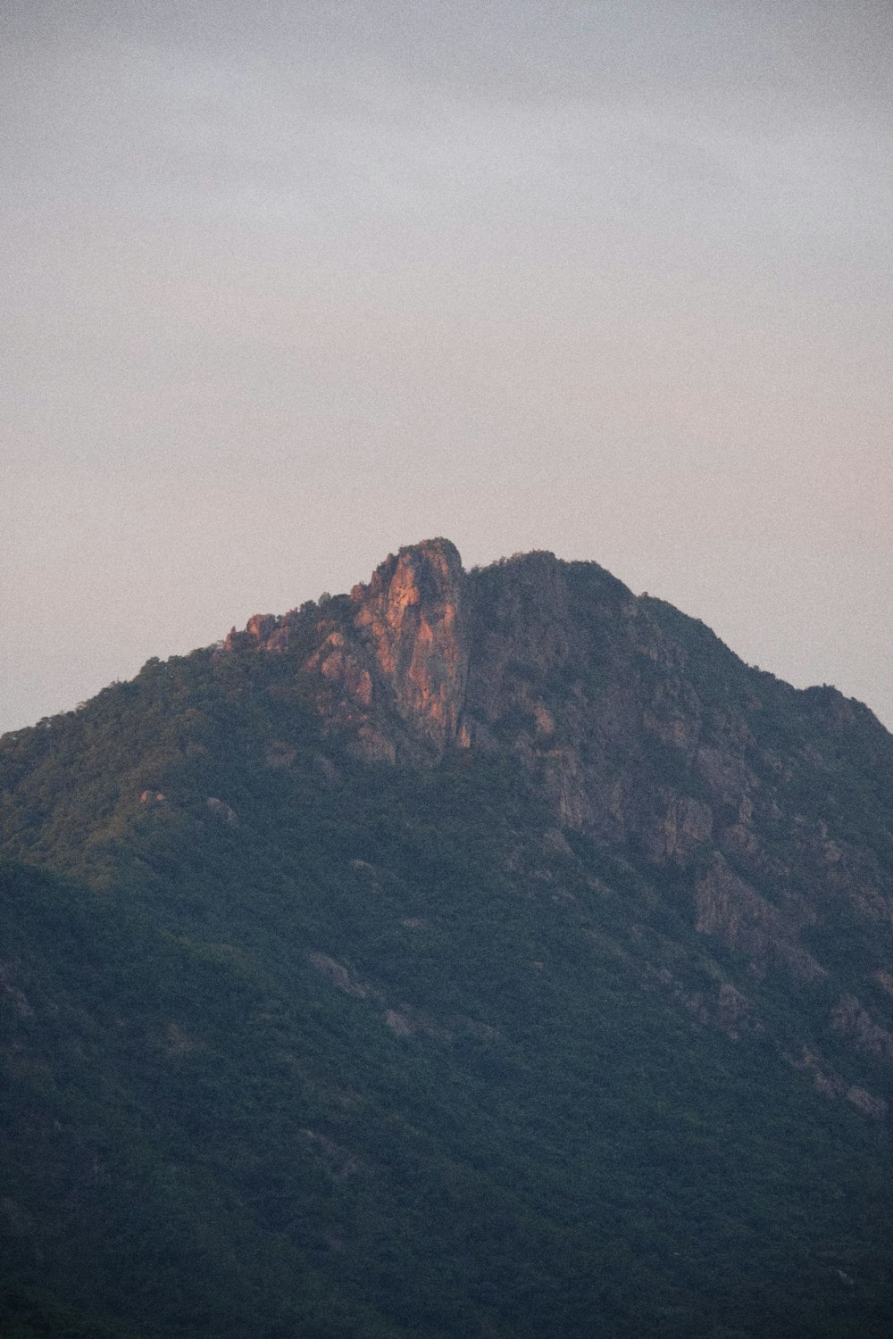 a mountain with a foggy sky