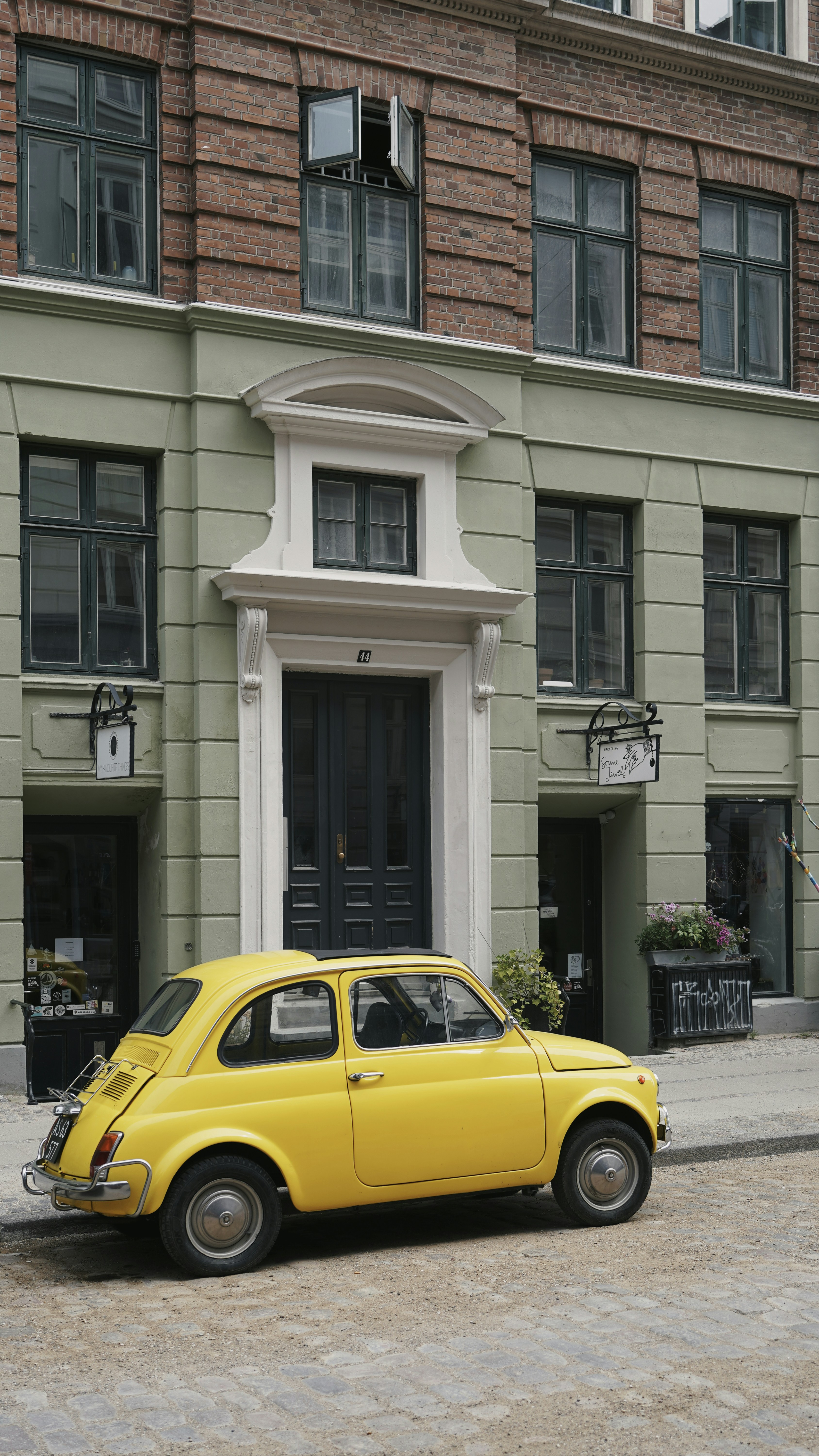 a yellow car parked in front of a building