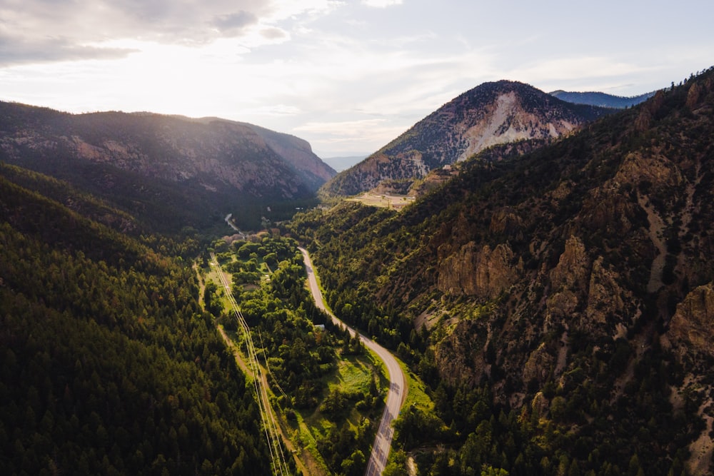 a winding road through a valley between mountains