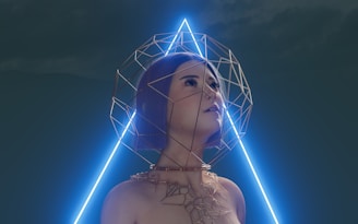 A woman gazes upward with a serene expression, surrounded by a geometric wireframe structure resembling a halo. This structure extends from her neck, forming intricate patterns around her shoulders. A glowing triangular neon light is positioned behind her, casting a futuristic ambiance against a dark background.