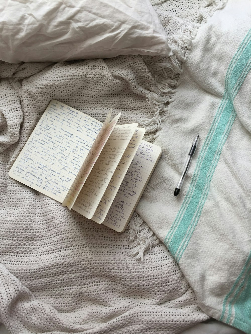 a book and a pen on a bed