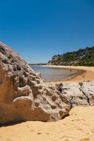 a body of water with a rocky shore and trees on the side