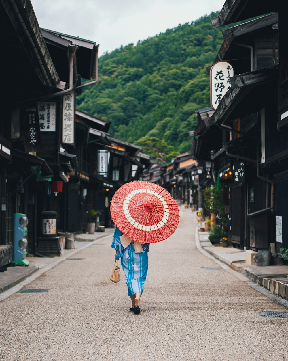 a person walking down a street holding an umbrella