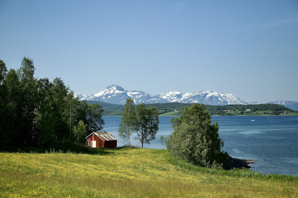 a house by a lake with mountains in the background