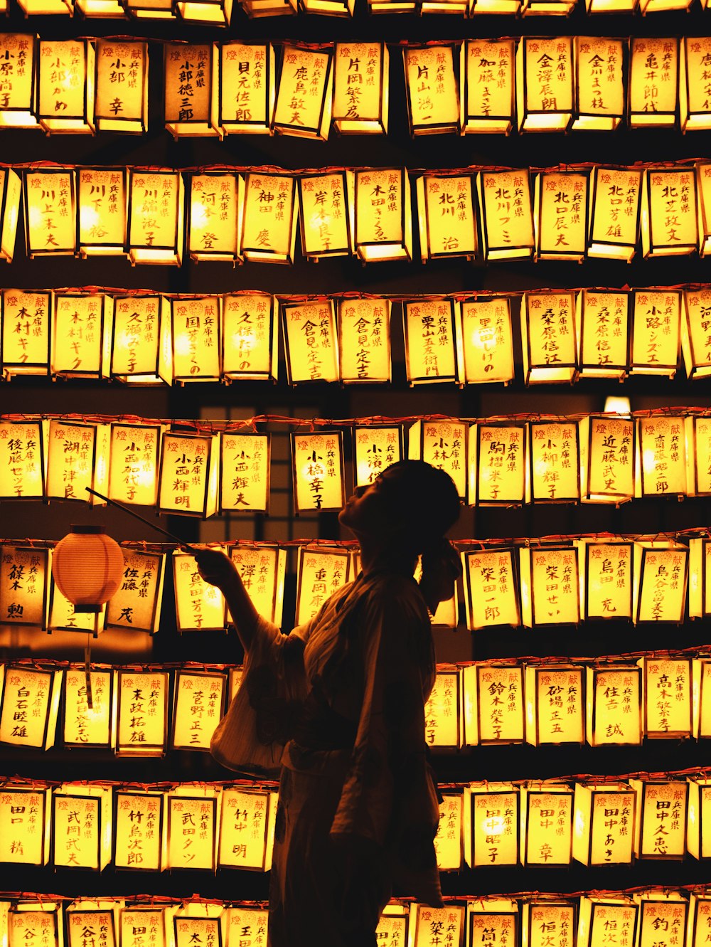 a person standing in front of a wall of lights