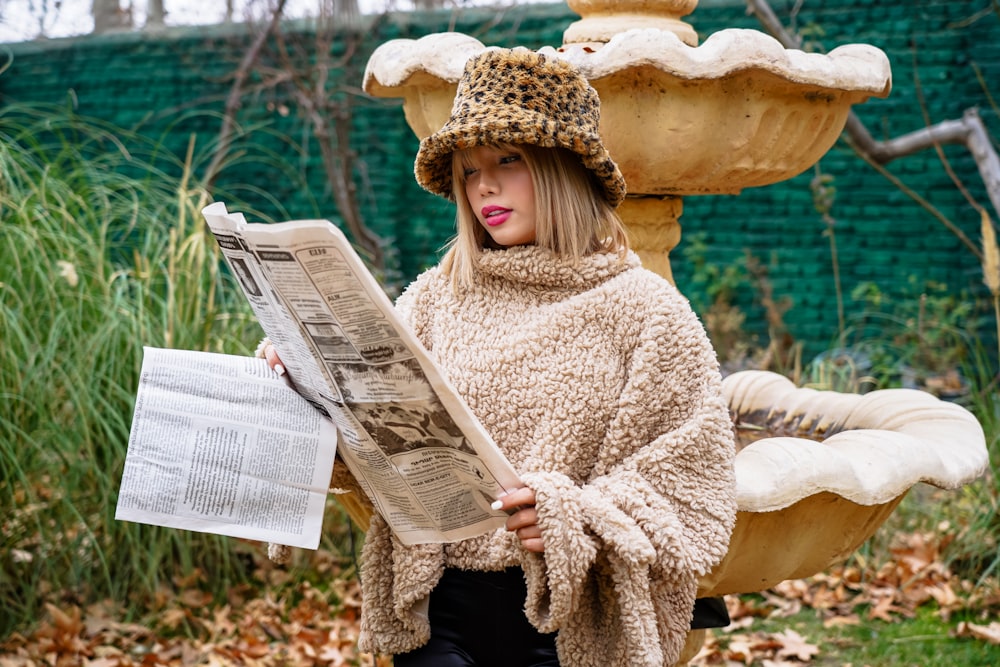 a woman sitting on a bench reading a book