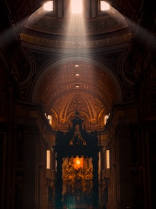 Sunlight streaming through stained glass onto a wooden altar during Holy Mass.
