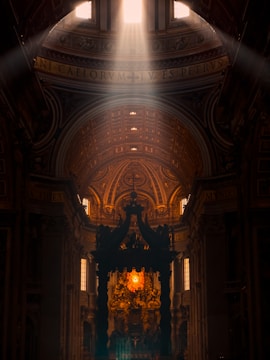 Sunlight streaming through stained glass windows illuminating the synagogue’s prayer hall.