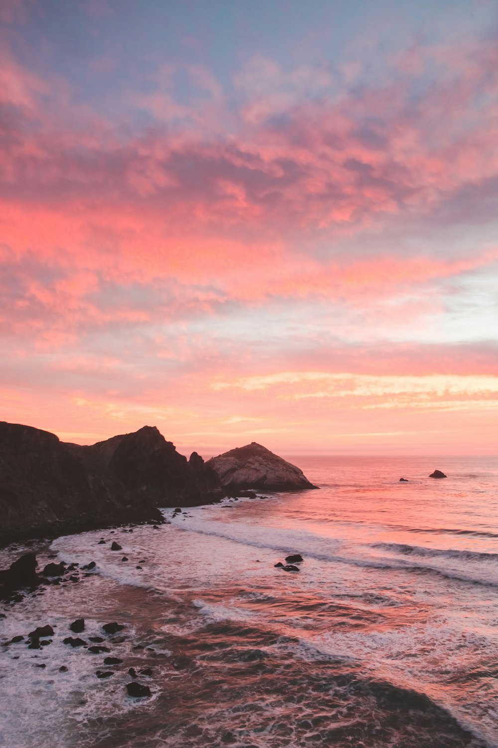 a beach with rocks and a sunset