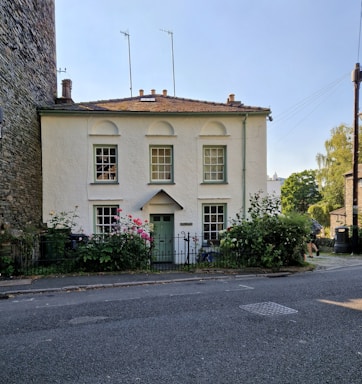 Cozy family house surrounded by greenery and a white fence.