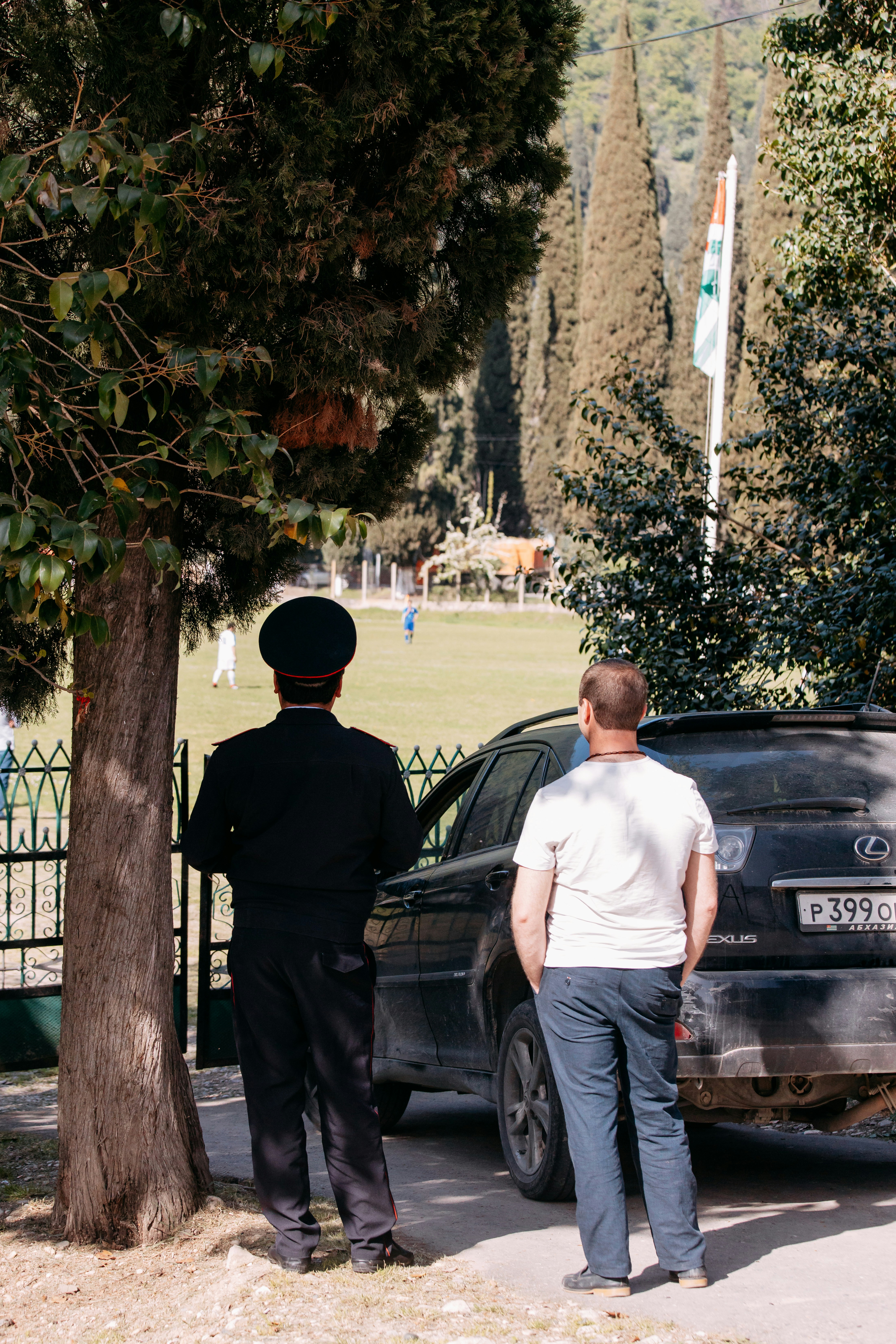 Deux hommes debout à côté d’une voiture