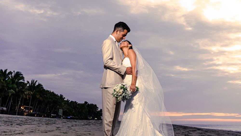 a man and woman kissing on a beach