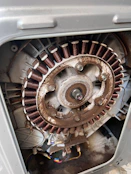 Motor eléctrico industrial en proceso de rebobinado con devanados de cobre visibles.