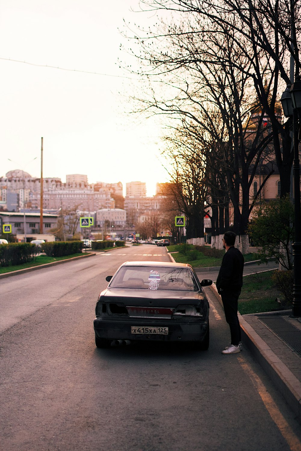 a person standing next to a car on a street