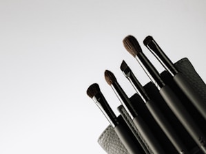 A sleek black and silver makeup brush set arranged elegantly on a glossy surface.