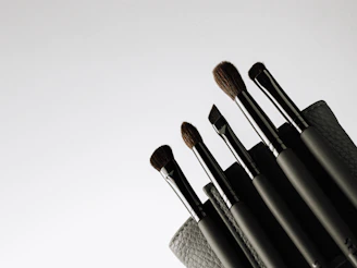 Elegant makeup brushes and palettes displayed on a sleek black background