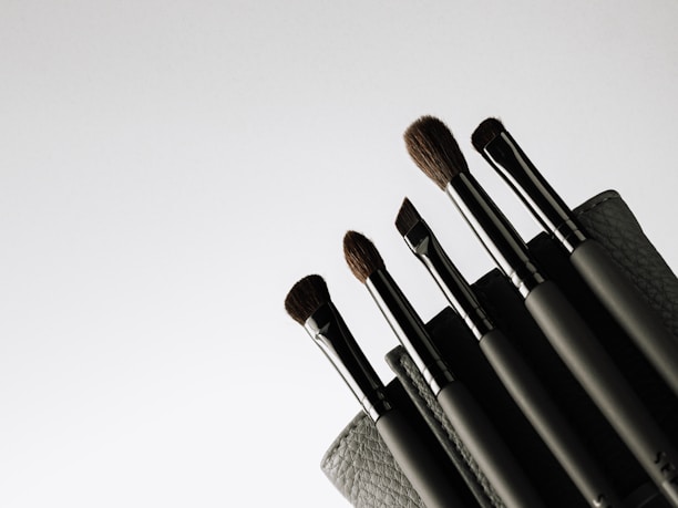 A sleek black and silver makeup brush set arranged elegantly on a glossy surface.