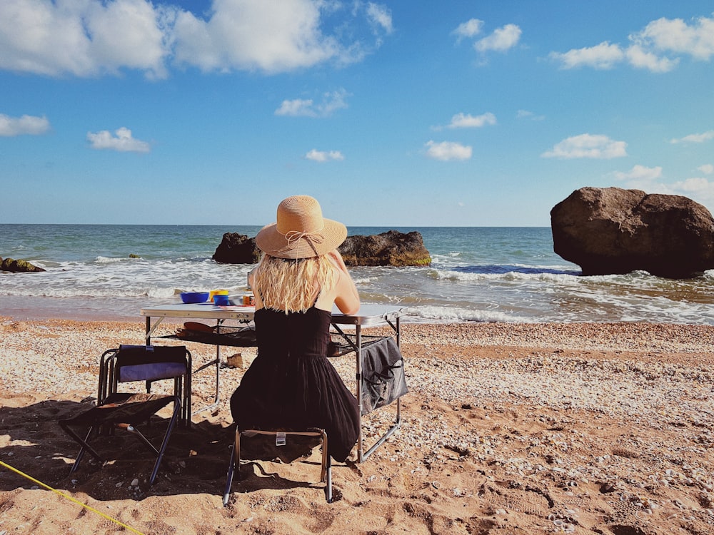 a person sitting at a table on a beach