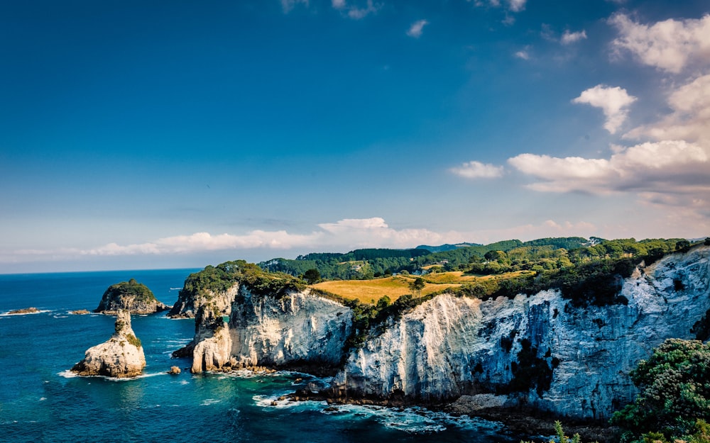 a rocky cliff with a body of water below