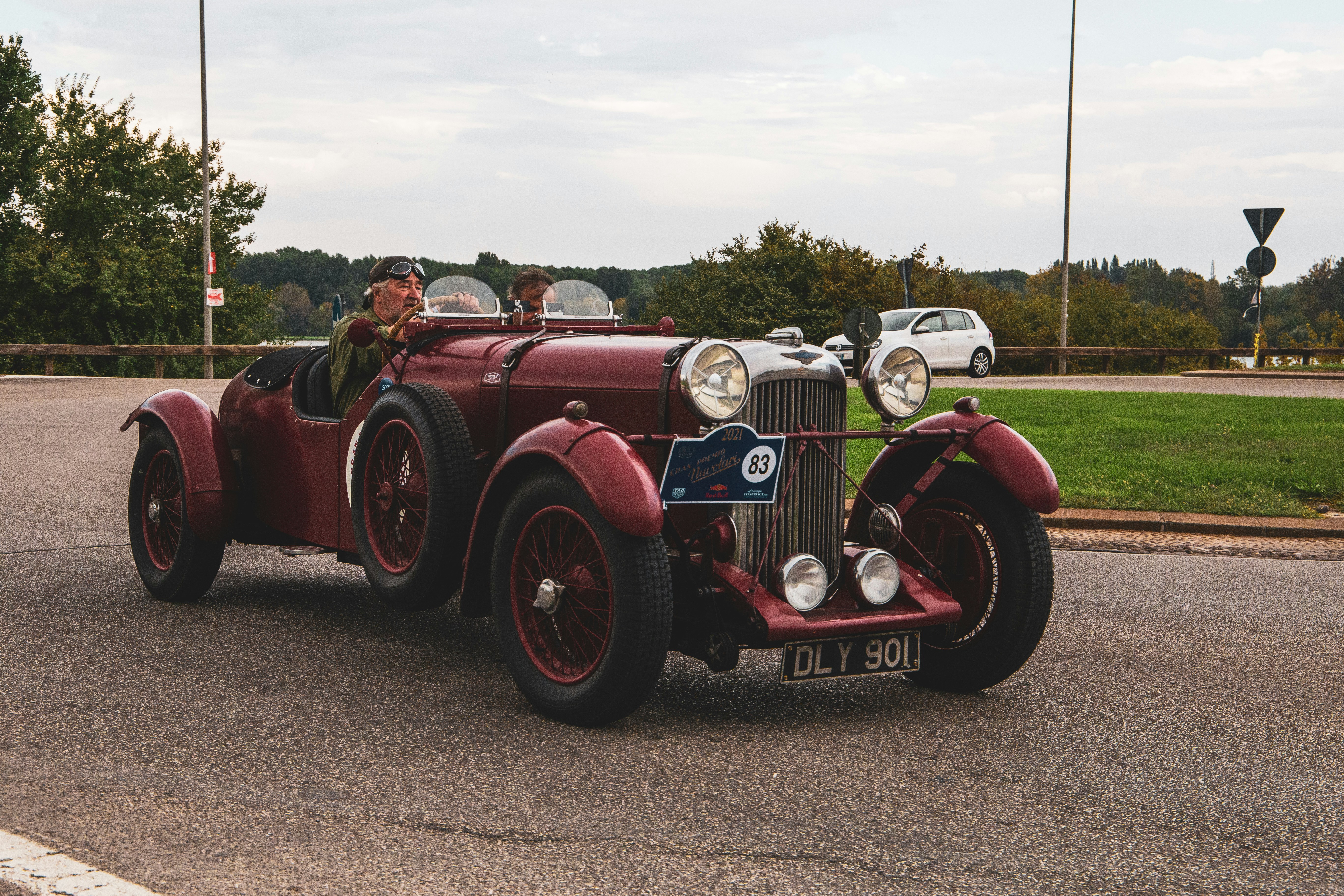 a couple of people in a red car on a road