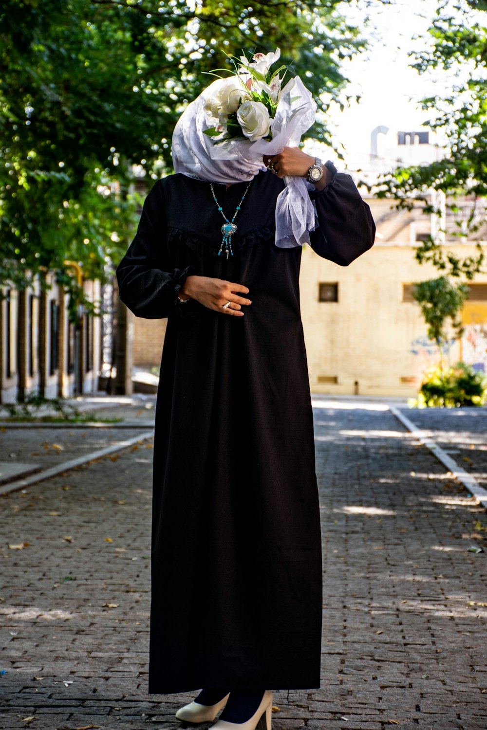 a person in a black dress holding flowers