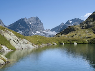 A scenic mountain landscape reflecting in a calm alpine lake.