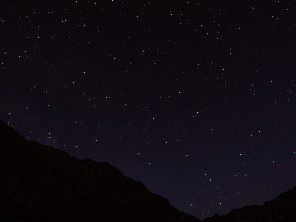 a starry night sky over a mountain range