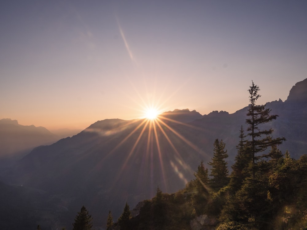 a sun shining over a mountain