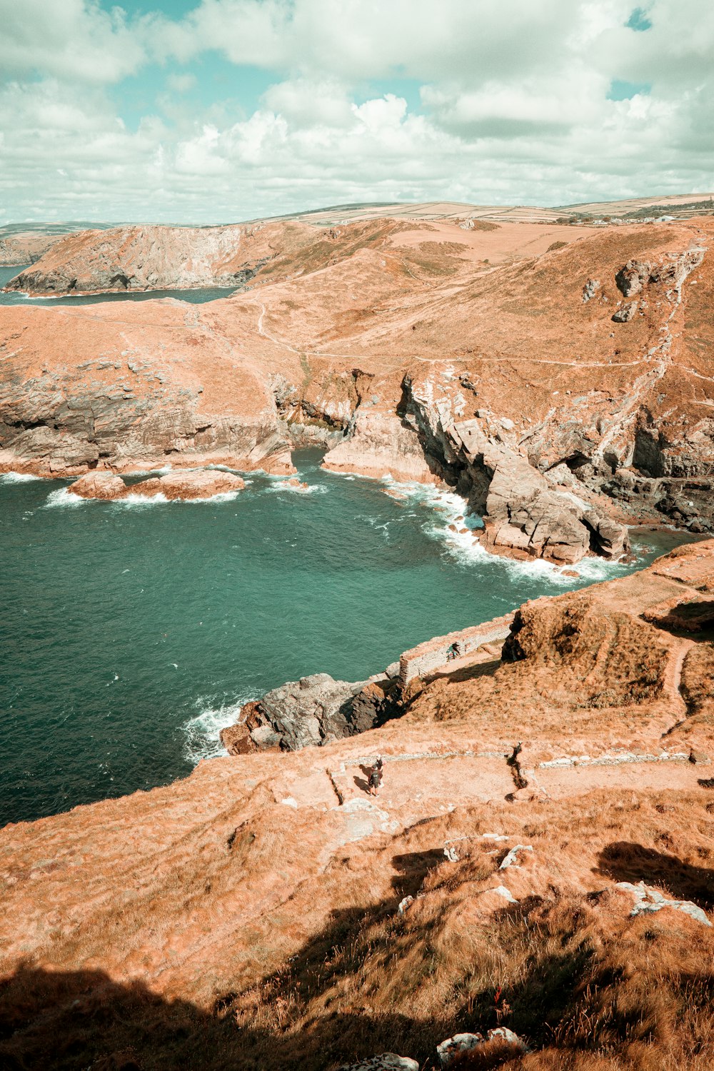 a rocky beach with a body of water in the background